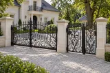 Brama wjazdowa dwuskrzydłowa kuta z motywem ornamentalnym, model BU50 — aranżacja europejskiej posesji z dopasowanymi elementami ogrodzenia. Wizualizacja AI.