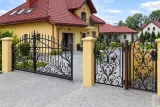 Brama wjazdowa dwuskrzydłowa kuta z motywem ornamentalnym, model BU50 — odtworzone ujęcie oryginalne. Wizualizacja AI.
