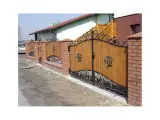 Wyrób kuty: Brama Wjazdowa Kuta Dwuskrzydłowa z Aplikacjami Ornamentalnymi i Drewnianym Wypełnieniem