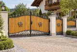 Brama wjazdowa kuta dwuskrzydłowa z aplikacjami ornamentalnymi i drewnianym wypełnieniem, model BU45 — aranżacja europejskiej posesji z dopasowanymi elementami ogrodzenia. Wizualizacja AI.