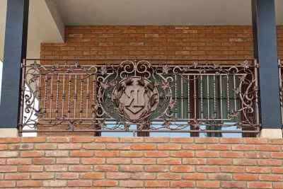Kuta balustrada balkonowa z motywami winorośli i monogramem, model BKZ07 — odtworzone ujęcie oryginalne. Wizualizacja AI.