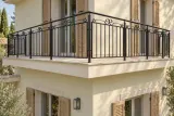Kuta balustrada balkonowa zewnętrzna z motywem wolutowym, model BKZ12 — aranżacja w nowej przestrzeni. Wizualizacja AI.