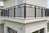Kuta balustrada balkonowa zewnętrzna z motywem wolutowym, model BKZ12 — odtworzone ujęcie oryginalne. Wizualizacja AI.