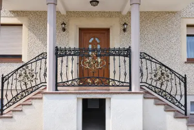 Kuta balustrada zewnętrzna klasyczna z złoconymi elementami floralnymi, model BKZ73 — odtworzone ujęcie oryginalne. Wizualizacja AI.