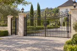 Kuta brama dwuskrzydłowa z ornamentyką florystyczną i inicjałami, model BU132 — aranżacja europejskiej posesji z dopasowanymi elementami ogrodzenia. Wizualizacja AI.