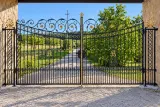 Kuta brama dwuskrzydłowa z ornamentyką florystyczną i inicjałami, model BU132 — odtworzone ujęcie oryginalne. Wizualizacja AI.