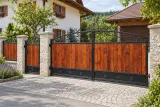 Kuta brama uchylna z elementami drewnianymi i ornamentyką klasyczną, model BU102 — aranżacja europejskiej posesji z dopasowanymi elementami ogrodzenia. Wizualizacja AI.