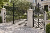 Kuta brama wjazdowa ornamentalna z furtką, model BU112 — aranżacja europejskiej posesji z dopasowanymi elementami ogrodzenia. Wizualizacja AI.