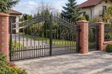 Kuta brama wjazdowa uchylna z dekoracyjnym wypełnieniem, model BU34 — aranżacja europejskiej posesji z dopasowanymi elementami ogrodzenia. Wizualizacja AI.