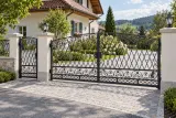 Kuta brama wjazdowa uchylna z klasycznymi zdobieniami, model BU35 — aranżacja europejskiej posesji z dopasowaną furtką i przęsłem ogrodzeniowym. Wizualizacja AI.