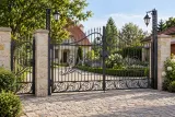 Kuta brama wjazdowa uchylna z ornamentyką klasyczną, model BU40 — aranżacja europejskiej posesji z dopasowaną furtką i przęsłem ogrodzeniowym. Wizualizacja AI.