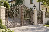 Kuta brama wjazdowa uchylna z ornamentyką winorośli, model BU92 — aranżacja europejskiej posesji z dopasowanymi elementami ogrodzenia. Wizualizacja AI.