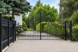 Kuta brama wjazdowa uchylna z ozdobnymi ornamentami, model BU86 — odtworzone ujęcie oryginalne. Wizualizacja AI.