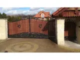 Wyrób kuty: Kuta Brama Wjazdowa Uchylna z Panelami Drewnianymi i Ornamentyką Klasyczną