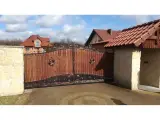 Wyrób kuty: Kuta Brama Wjazdowa Uchylna z Panelami Drewnianymi i Ornamentyką Klasyczną