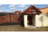 Wyrób kuty: Kuta Brama Wjazdowa Uchylna z Panelami Drewnianymi i Ornamentyką Klasyczną
