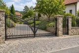 Kuta brama wjazdowa uchylna z spiralnymi ornamentami, model BU96 — aranżacja europejskiej posesji z dopasowanymi elementami ogrodzenia. Wizualizacja AI.