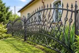 Kute ogrodzenie architektoniczne z elementami scrollowymi, model OK27 — odtworzone ujęcie oryginalne. Wizualizacja AI.