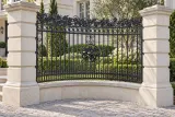 Kute przęsło ogrodzeniowe łukowe z dekoracją winorośli, model ok78 — aranżacja: klasyczna kremowa rezydencja z łukowym kamiennym dojściem. Wizualizacja AI.