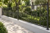 Kute przęsło ogrodzeniowe zewnętrzne z klasyczną ornamentyką, model OK19 — aranżacja: zacieniony ogród willowy z jasnym brukiem kamiennym. Wizualizacja AI.