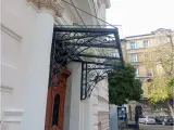 Wyrób kuty: Kuty Daszek Wejściowy ze Szklanym Panelem i Ornamentyką Kowalską
