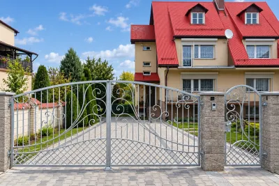 Kuty zespół wjazdowy: brama dwuskrzydłowa i furtka z elementami rococo, model BU136 — odtworzone ujęcie oryginalne. Wizualizacja AI.