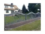 Wyrób kuty: Ogrodzenie kute ze stali z falistymi przęsłami i okrągłymi elementami ozdobnymi