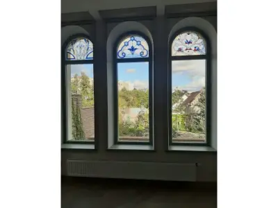 Wyrób kuty: Witrażowe Okno z Kutej Stali o Stylizowanej Ornamentyce